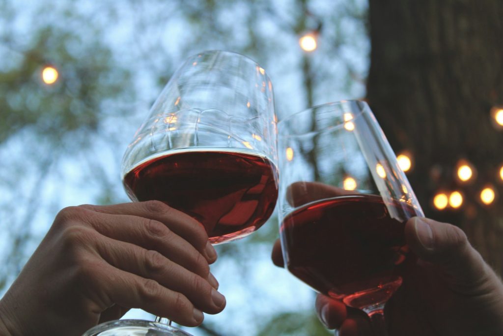 Verre de vin rouge tenu à la main, illustrant l'impact de l'alcool sur le sommeil