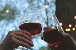 Verre de vin rouge tenu à la main, illustrant l'impact de l'alcool sur le sommeil