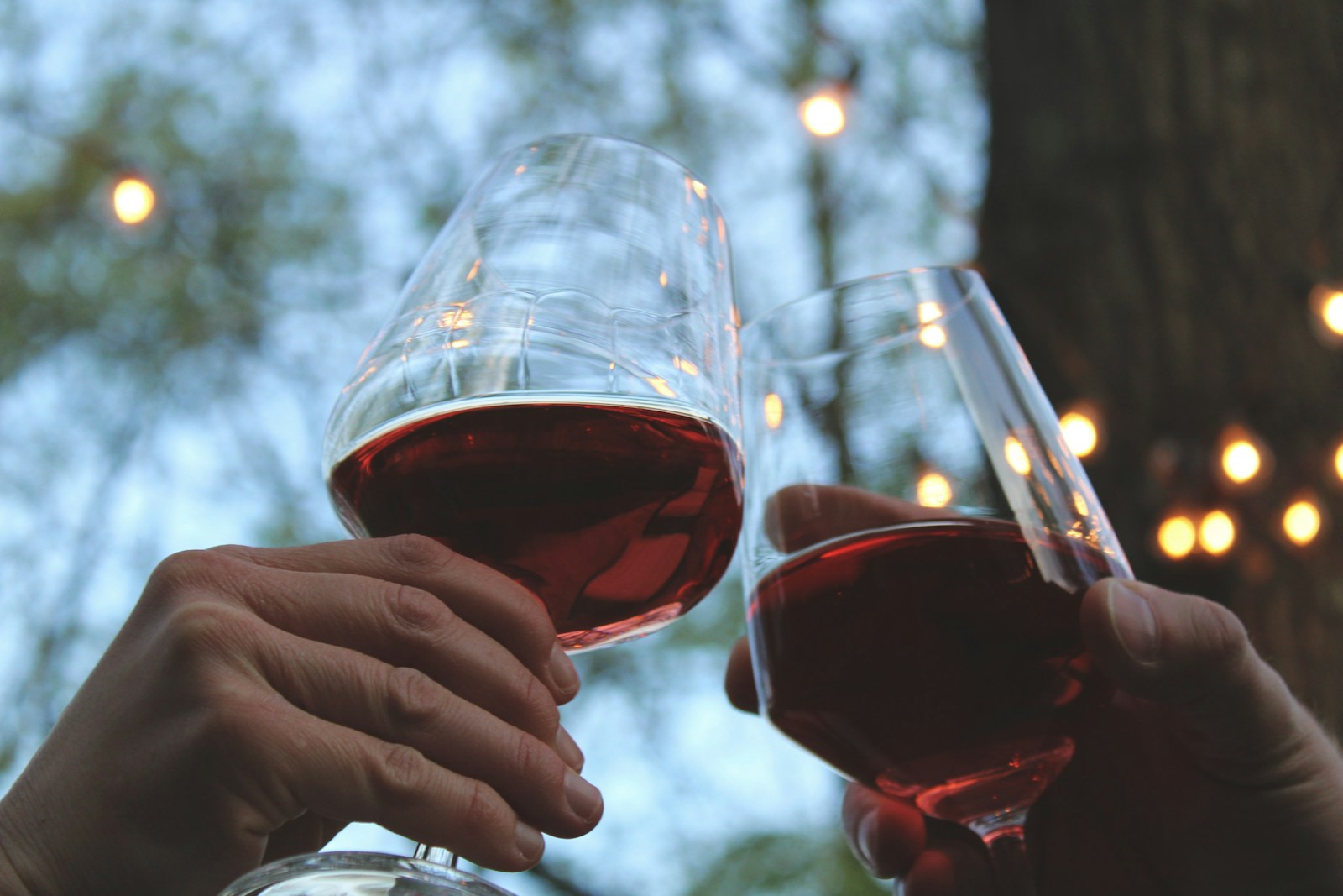 Verre de vin rouge tenu à la main, illustrant l'impact de l'alcool sur le sommeil