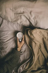 Tasse de cafe posee sur draps blancs la nuit - cafeine et sommeil