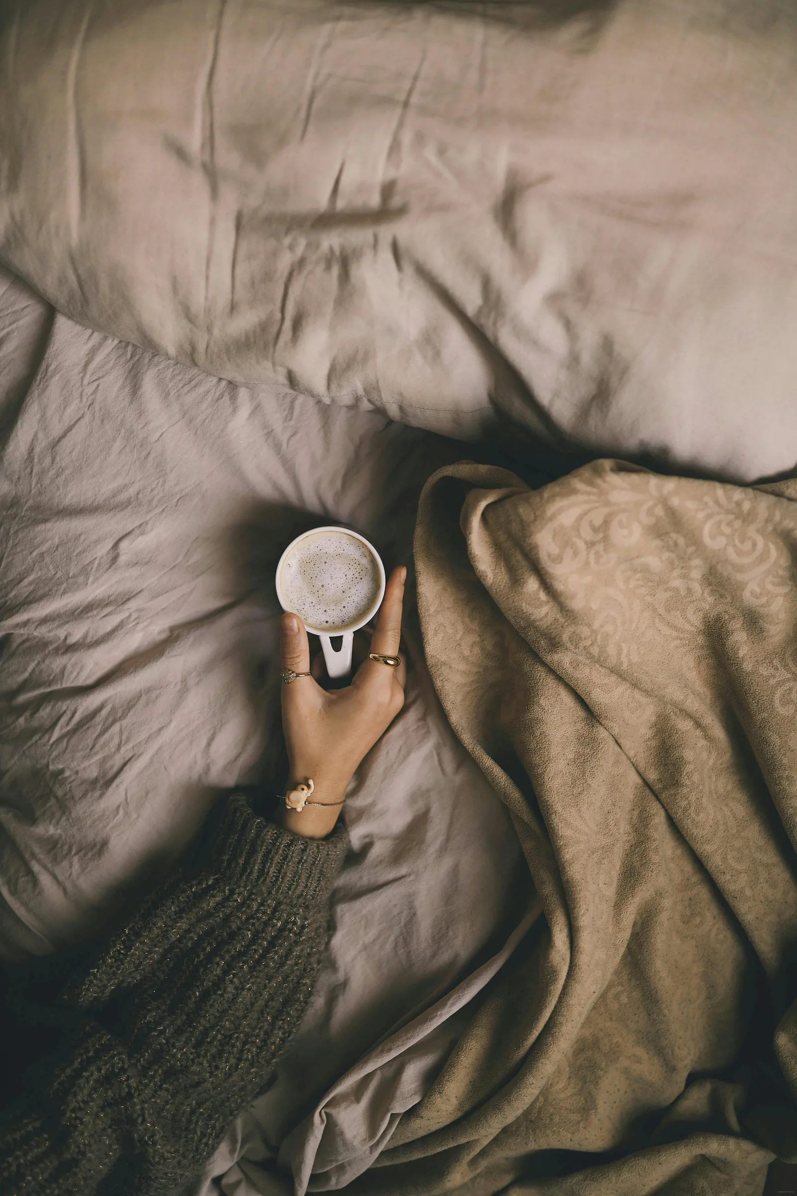Tasse de cafe posee sur draps blancs la nuit - cafeine et sommeil