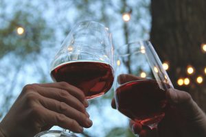 Verre de vin rouge tenu à la main, illustrant l'impact de l'alcool sur le sommeil
